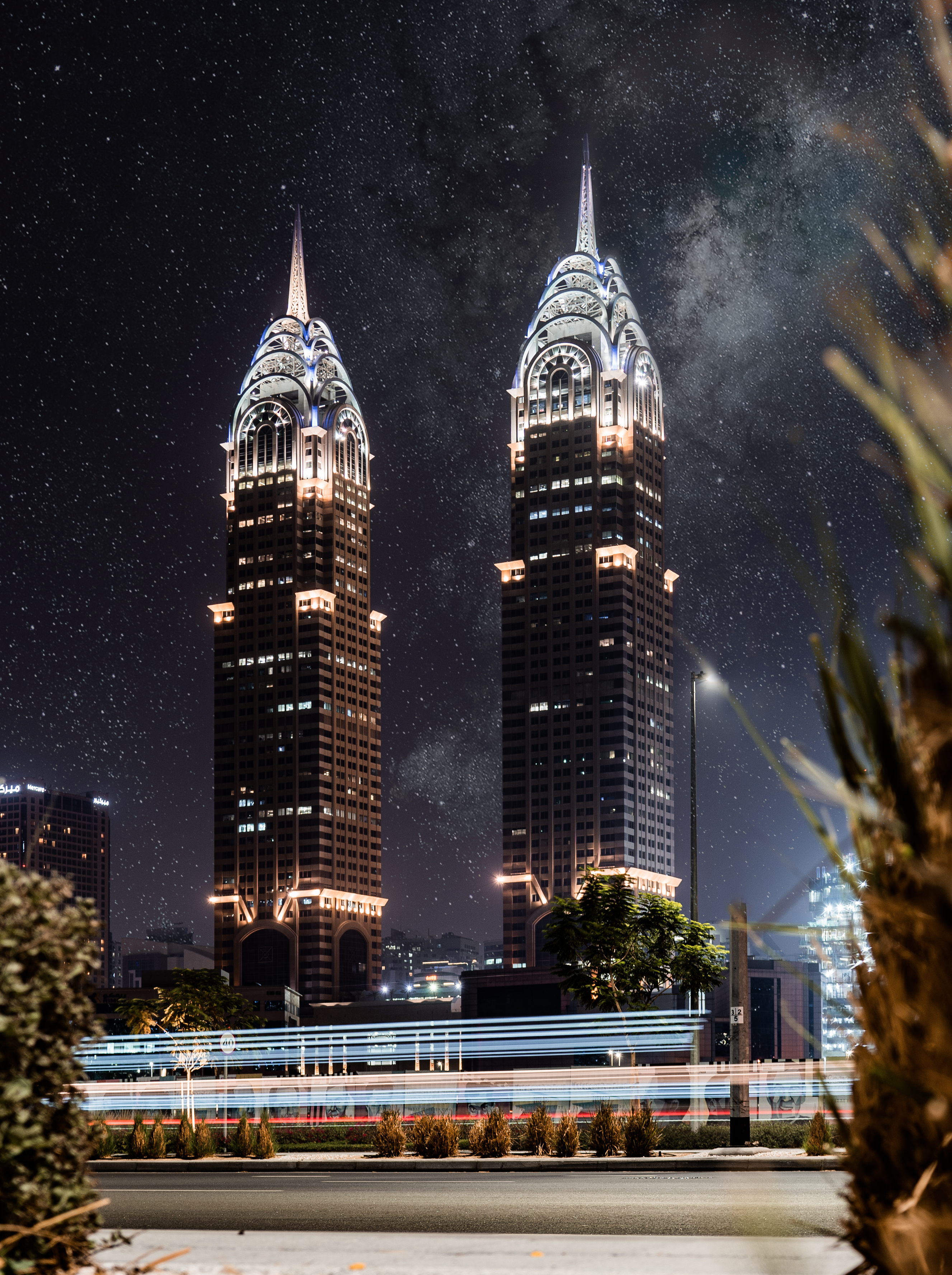 Towers of Business center in Dubai at night with beautiful ligtt paintings and night sky